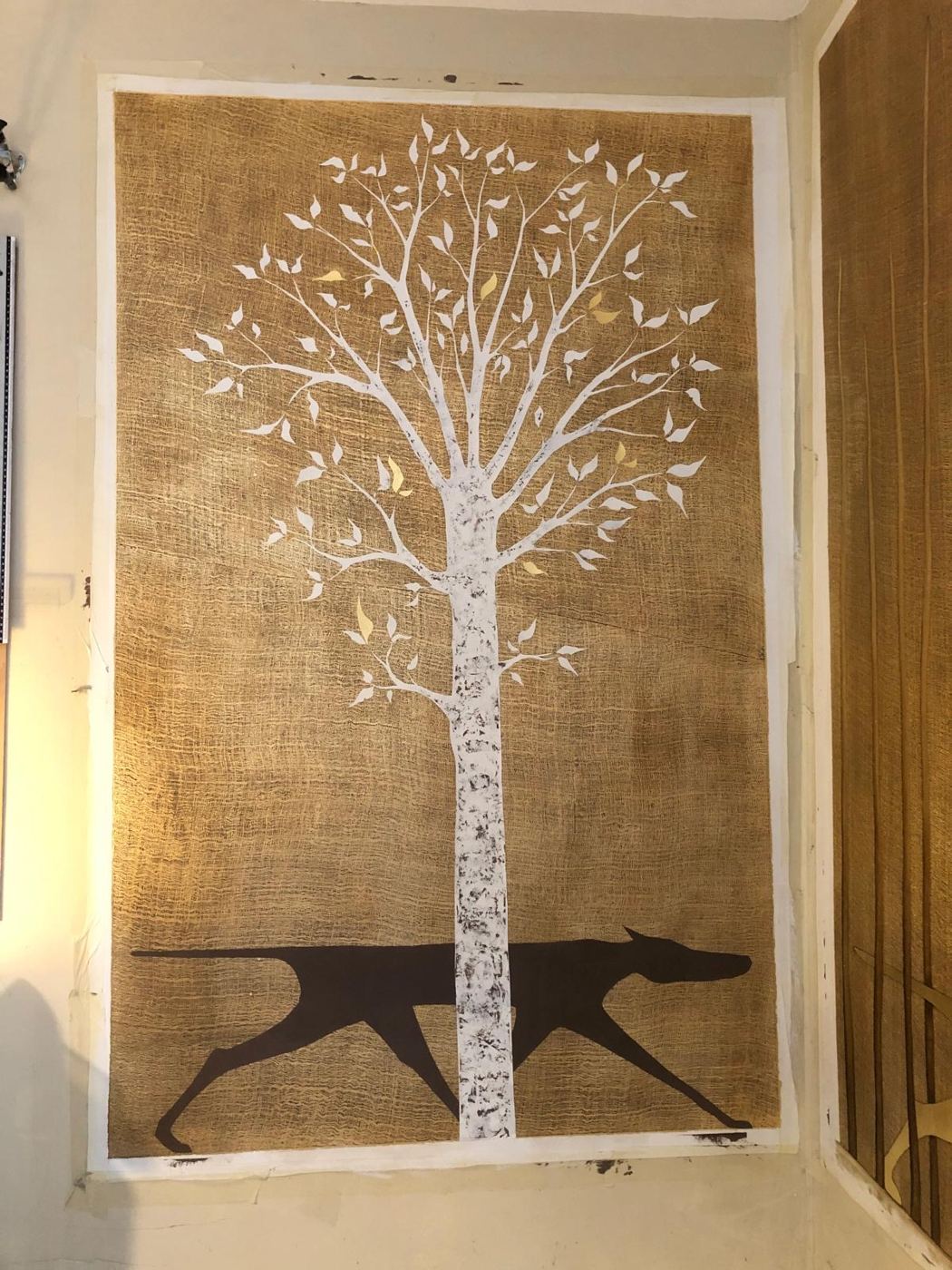 Toile peinte d'un arbre blanc et d'un chien sur fond doré texturé