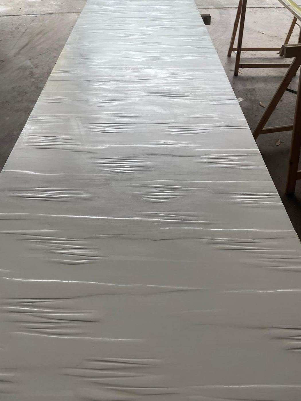 Grand panneau d'enduit gris lissé en ondulations, à l'atelier