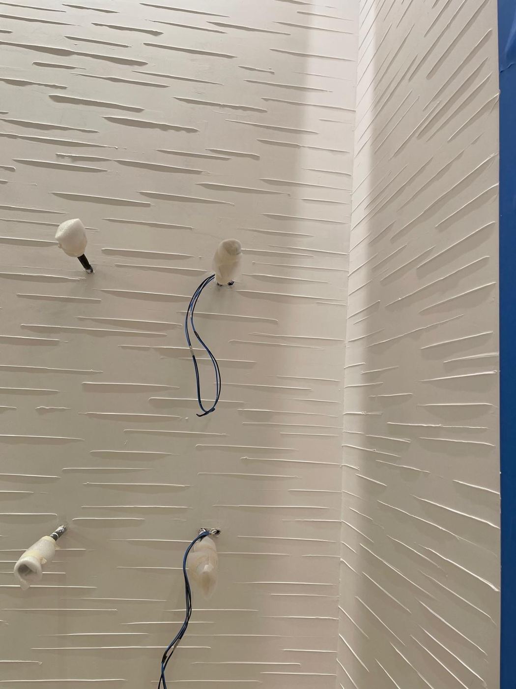 Mur blanc en enduit marqué de traits horizontaux à la lisseuse
