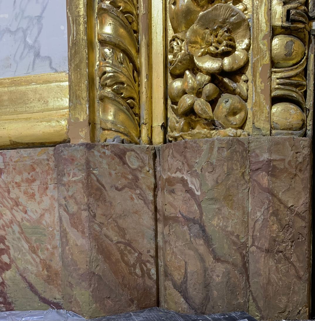 Soubassement en faux marbre restauré sous une boiserie dorée